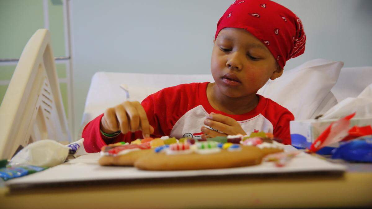 Adriana Nixon, 6, decorates a gingerbread man in her hospital room. She has hepatocellular carcinoma, or HCC, in her liver, a rare cancer found in less than 1 in a million children.