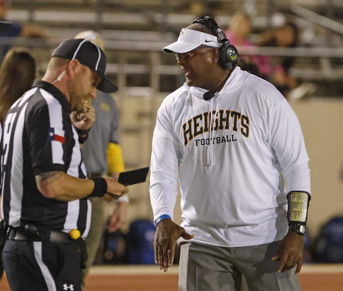 Arlington Heights head coach Curtis James discusses a call with head line judge David Fields during the first half of a UIL Conference 5A D1 Bi-District playoff game between Arlington Heights and Brewer at Farrington Field in Fort Worth, Texas, Friday, Nov. 14, 2025.