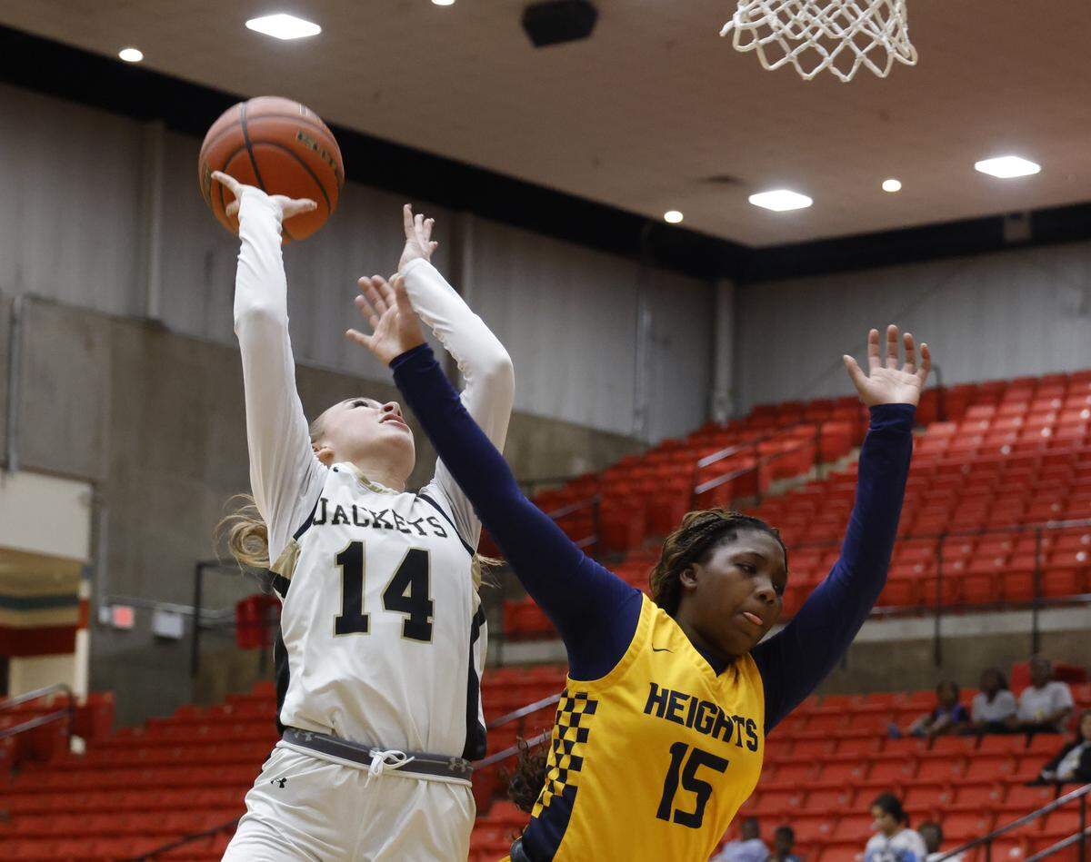 Arlington Heights guard Aleyah Ivory (15) attempts to block the shot by Cleburne guard Beckett Roe (14) during the first half of the UIL 5A D1 girls bi-district championship basketball game at Wilkerson Greines Activity Center in Fort Worth, Texas, Monday, Feb. 16, 2026.