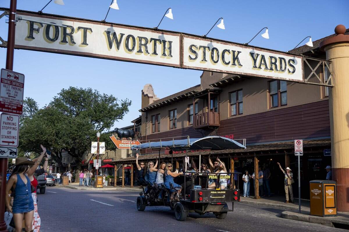 People ride the Pedal Saloon through the Fort Worth Stockyards on Friday, May 22, 2026 in Fort Worth, Texas. The Fort Worth Stockyards is a popular tourist attraction.