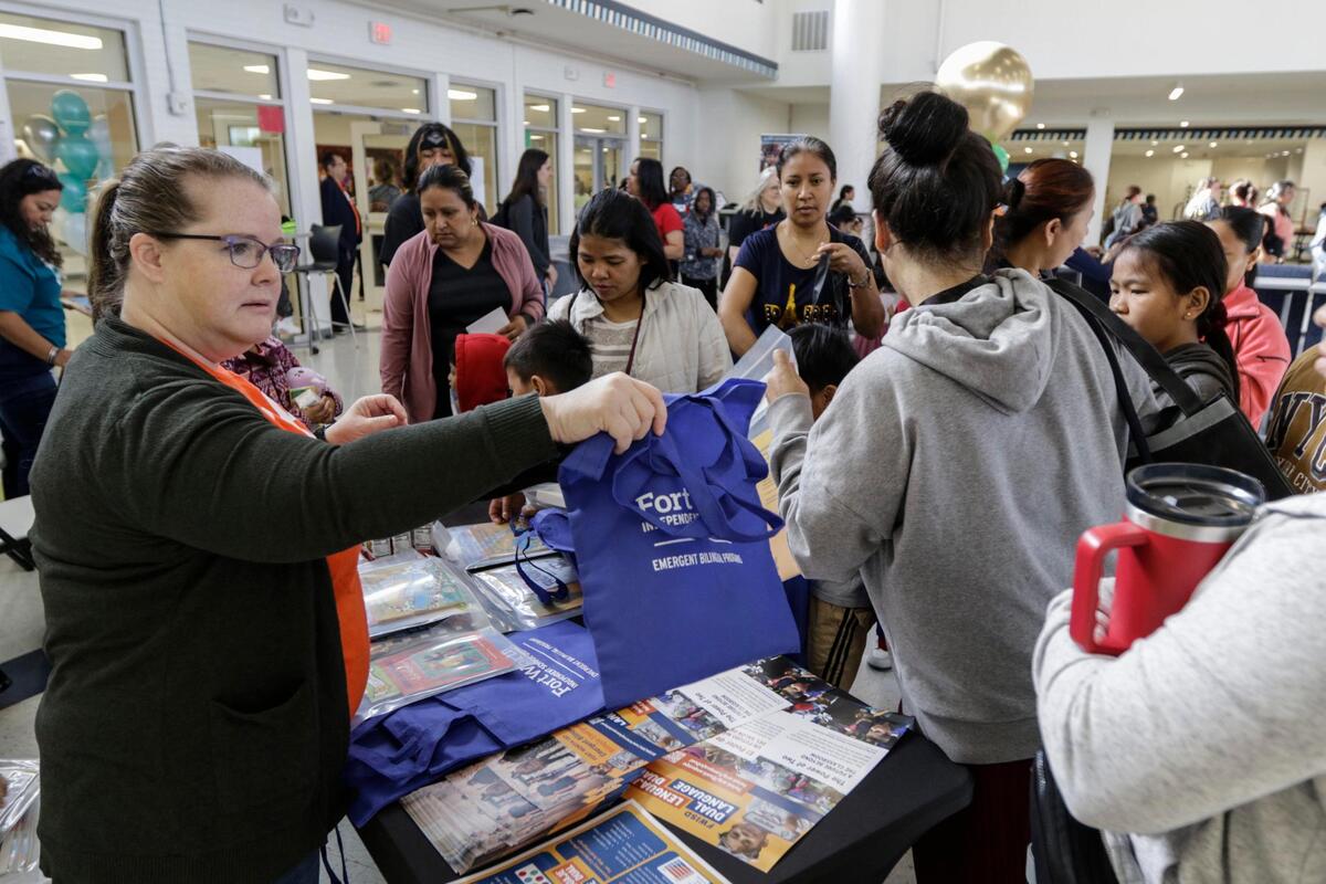 Fort Worth Independent School District hosts a family literacy conference on Saturday, April 12, at O.D. Wyatt High School. Meghan Well of the FWISD Emergent Bilingual Department passes out tote bags to families.