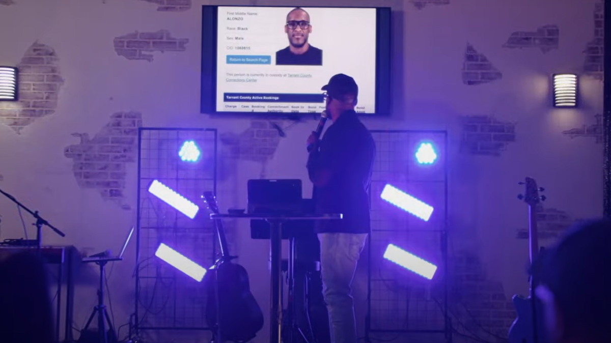 Pastor Diego Fuller displays his mugshot during a church service at Journey Fort Worth on Sunday, Sept. 7.