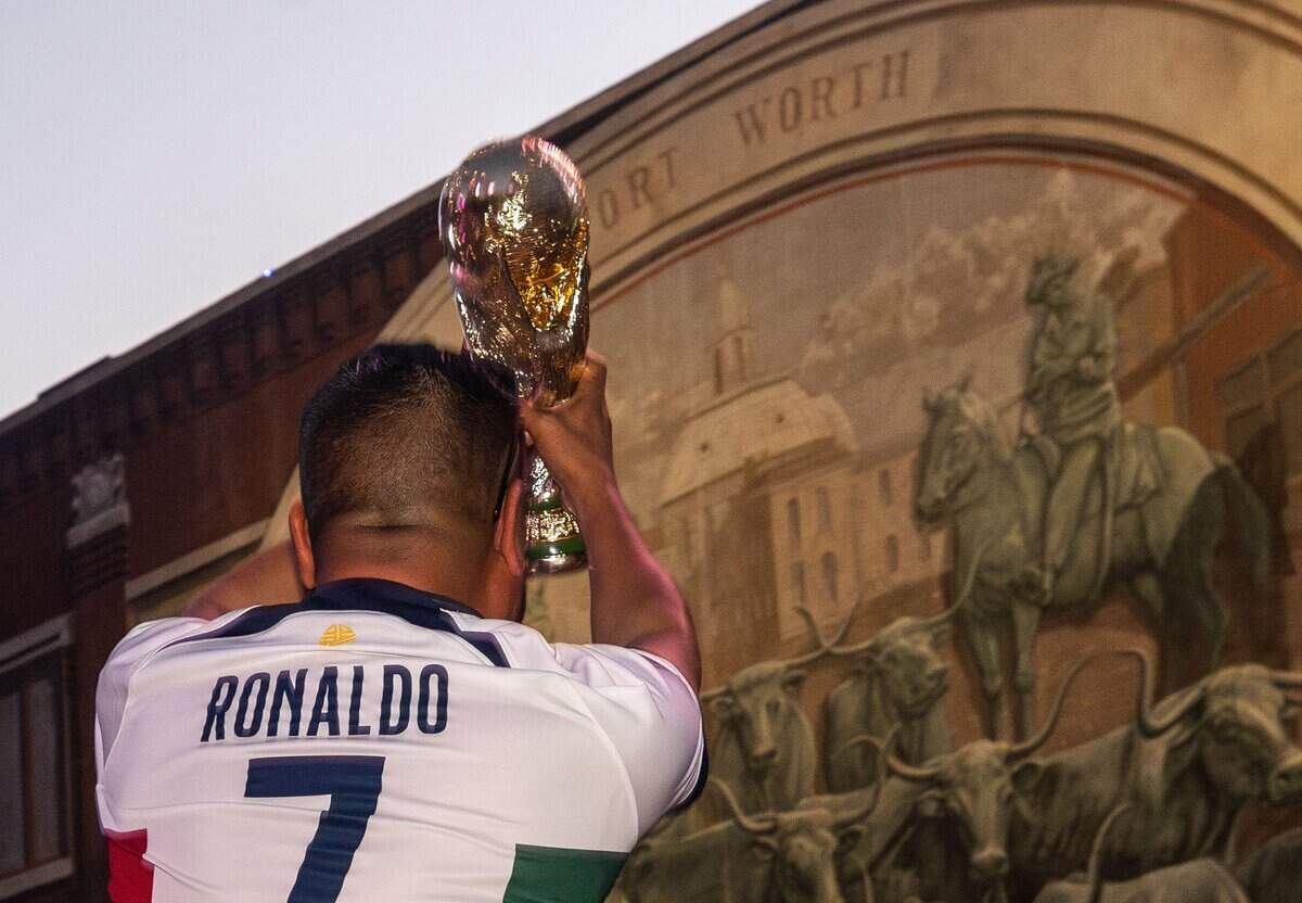 Carlos Garza holds a FIFA World Cup Trophy during a FIFA Summer of Soccer event at Sundance Square in Fort Worth on June 27, 2026.