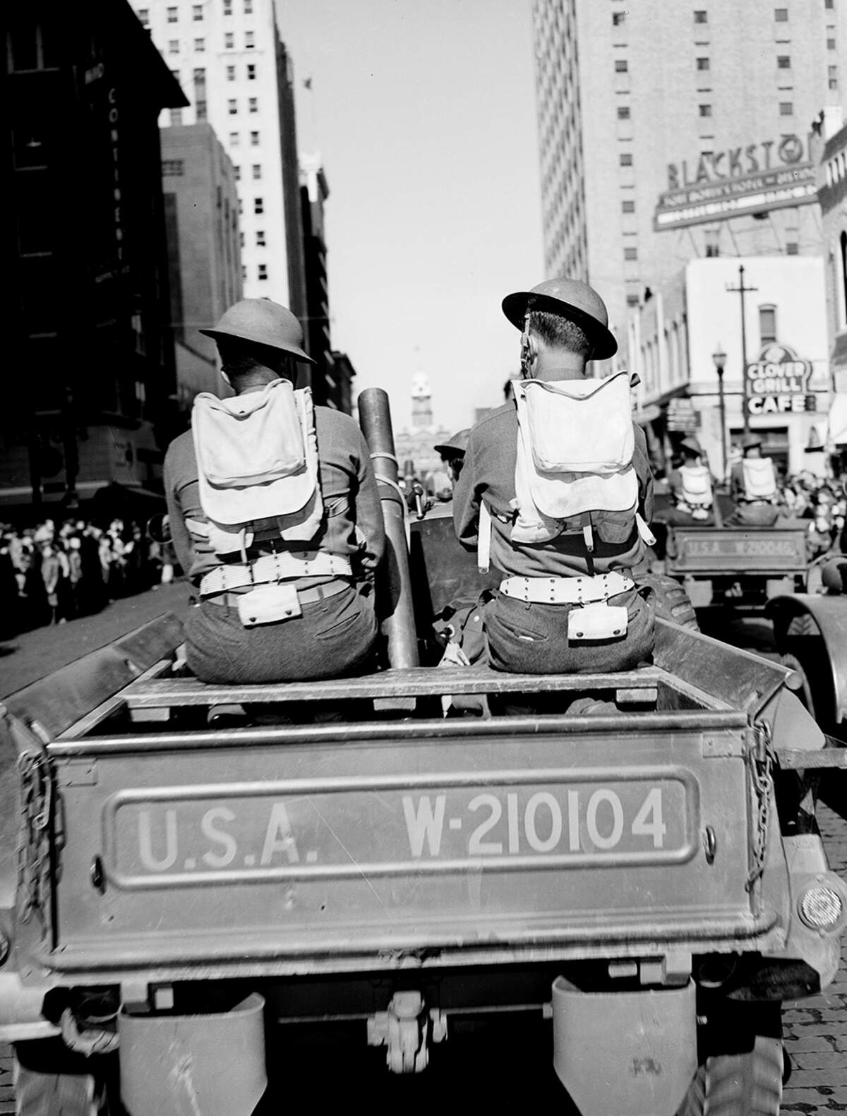 Nov. 11, 1941: Armistice Day parade in downtown Fort Worth. A long line of scout armored cars drive along the street as spectators watch.