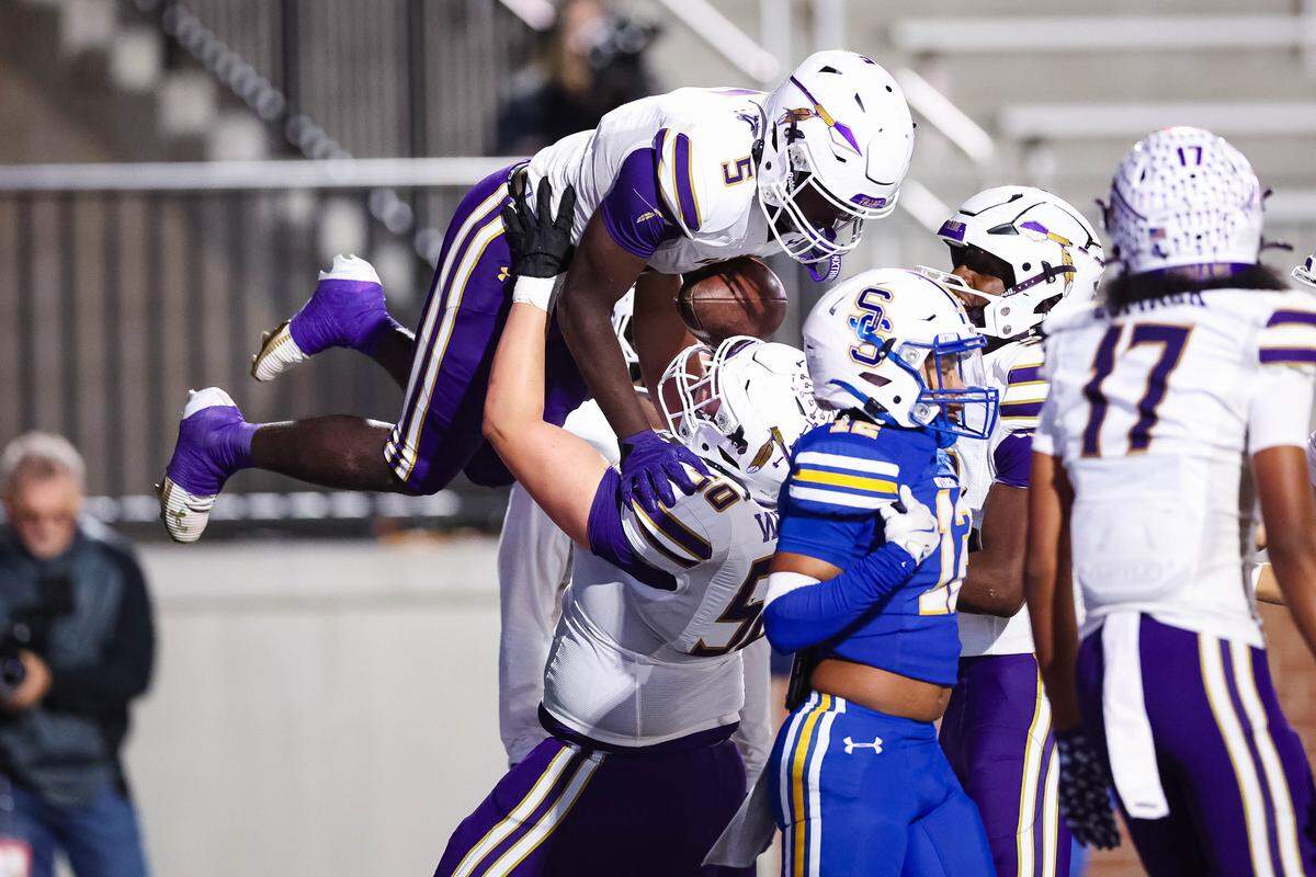 Alvarado offensive lineman Kenny White lifts running back Demarcus Belton in the air after a touchdown in a Class 4A Division I area playoff game against Sulphur Springs on Friday at Children’s Health Stadium in Prosper.