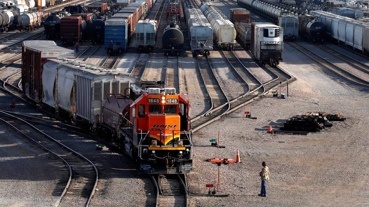 A BNSF rail terminal worker monitors the departure of a freight train in June 2021, in Galesburg, Illinois. Two major unions have rejected a tentative contract agreement. 