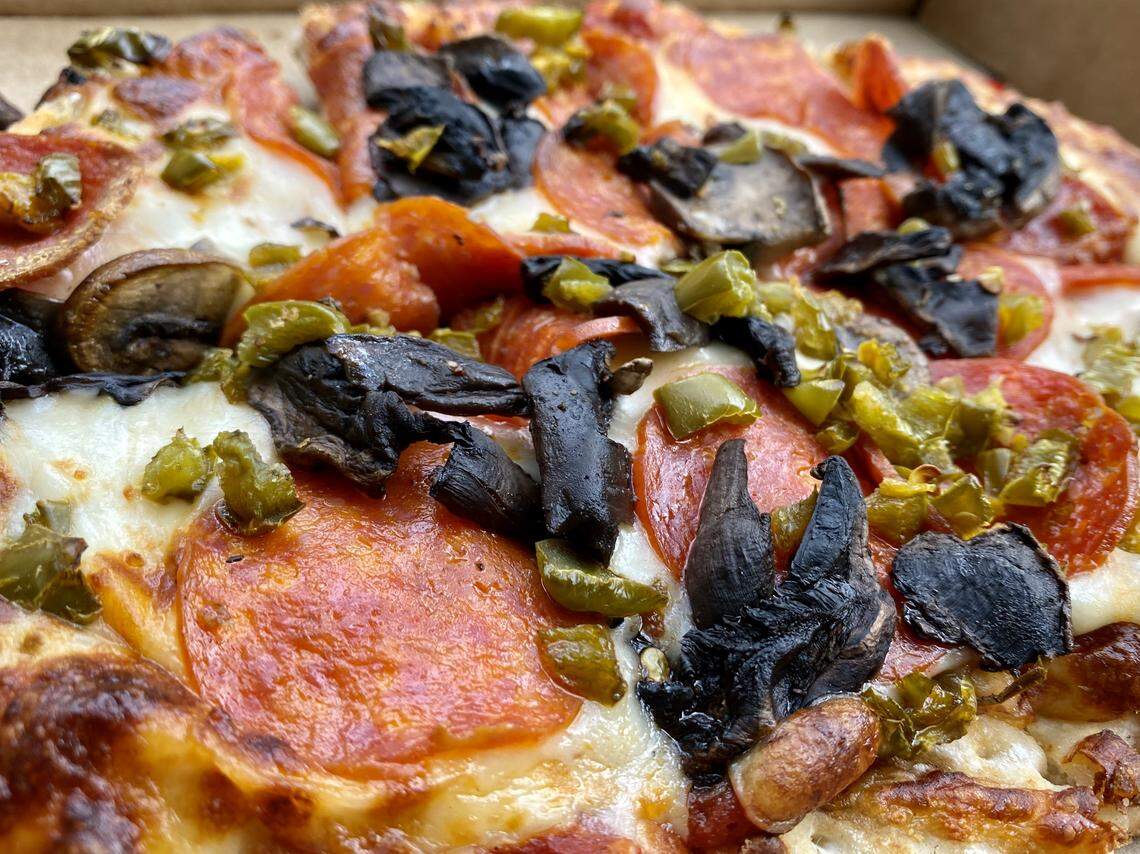 A pepperoni-sausage-and-mushroom pizza at ZuRoma Bar & Grill. (Cardboard take-out box not shown.)