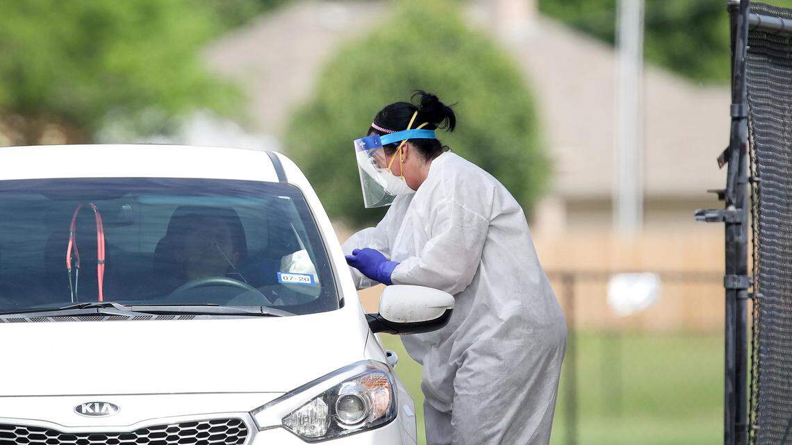 A nurse administers a COVID-19 test at a drive-through testing site in Burleson in April. A new study found that health care workers have almost twice as many cases than reported by the CDC.