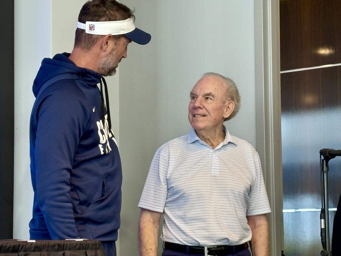 Dallas Cowboys legend Roger Staubach (right) talks to Cowboys head coach Brian Schottenheimer on Friday at The Star in Frisco, Texas.