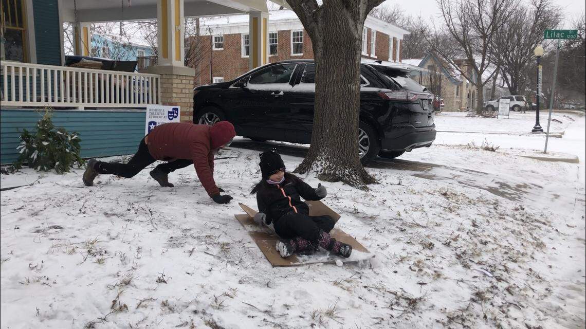 Tony Kopetchny pushes 8-year-old Lucia Kopetchny’s makeshift sled down a slope in the Near Southside neighborhood in Fort Worth during an unprecedented snowfall on Valentine’s Day.