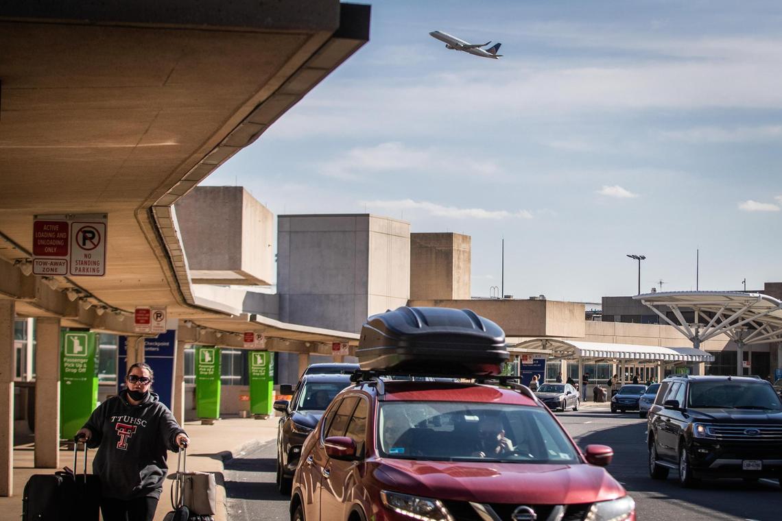 Cars wait for travelers at a terminal at DFW airport on Dec. 23, 2020.