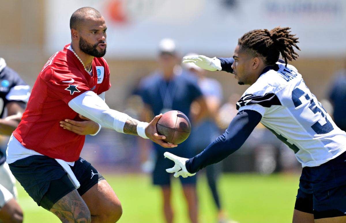 Dallas Cowboys quarterback Dak Prescott (4) hands off to running back Malik Davis (34) during training camp at River Ridge Playing Fields in Oxnard, Calif.