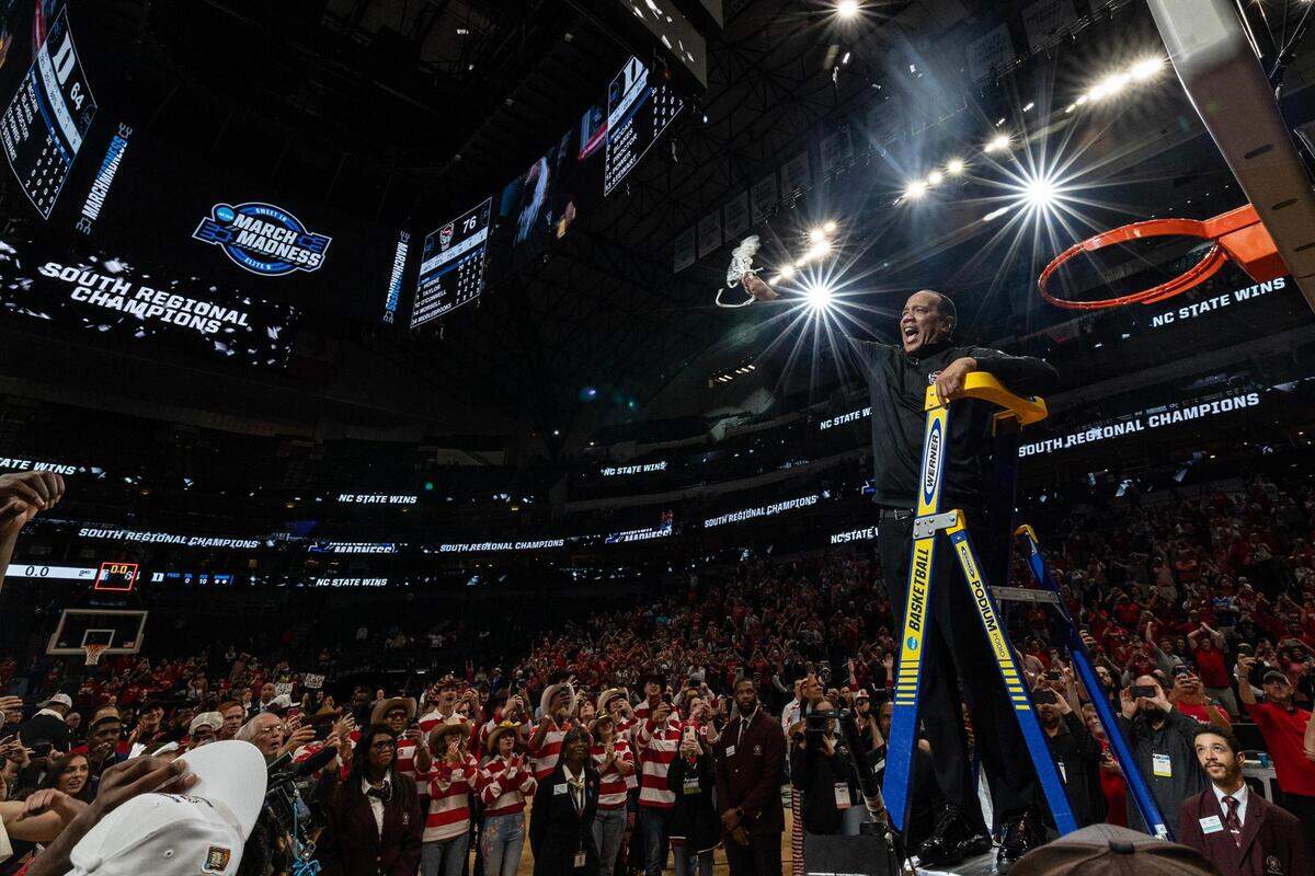 NC State Head Coach Kevin Keatts waves around the net after cutting it to celebrate after winning their Elite 8 South Regional match up against the Duke Blue Devils and advance to the Final Four of the NCAA Division I Mens Basketball Tournament at American Airlines Center in Dallas on Sunday, March 31, 2024. NC State defeated Duke 76-64.