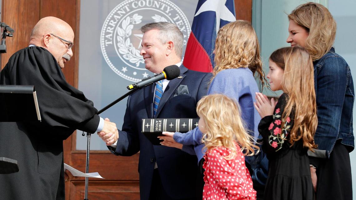 Tim O’Hare, standing with his family, is congratulated after he is sworn in as county judge on the steps of the Tarrant County Courthouse on Sunday.