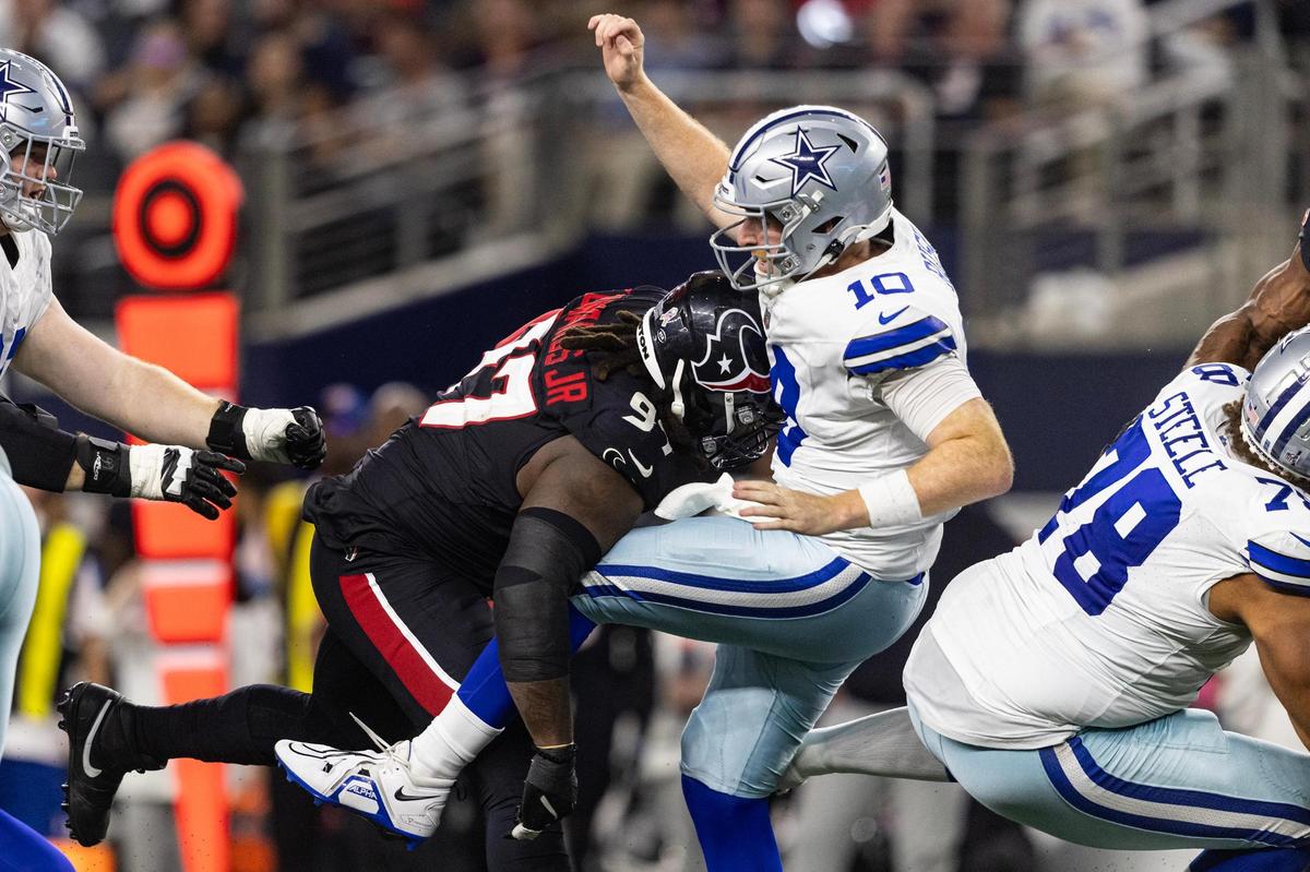 Texans defensive lineman Mario Edwards Jr. (97) tackles Cowboys quarterback Cooper Rush (10) in the second half of an NFL game between the Dallas Cowboys and the Houston Texans at AT&T Stadium in Arlington on Monday, Nov. 18, 2024.