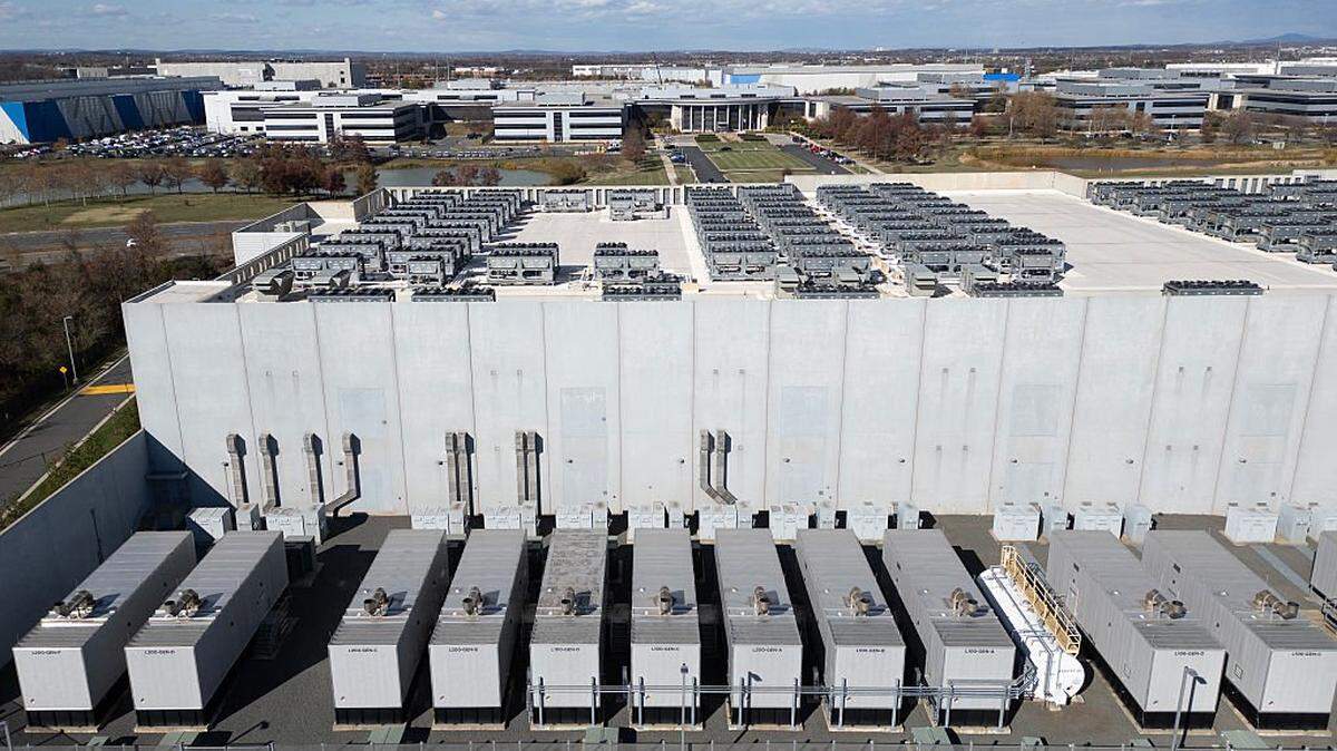 An aerial view shows cooling vent fans on the roof next to generators on the lower level of a Digital Realty data center in Ashburn, Virginia on November 12, 2025. Data centers are the physical infrastructure that make our digital lives possible, yet most people have never seen one up close or understand how they operate. Roughly 12,000 data centers are in operation in the world, with about half in the US, according to Cloudscene, a data center directory. (Photo by ANDREW CABALLERO-REYNOLDS / AFP via Getty Images)