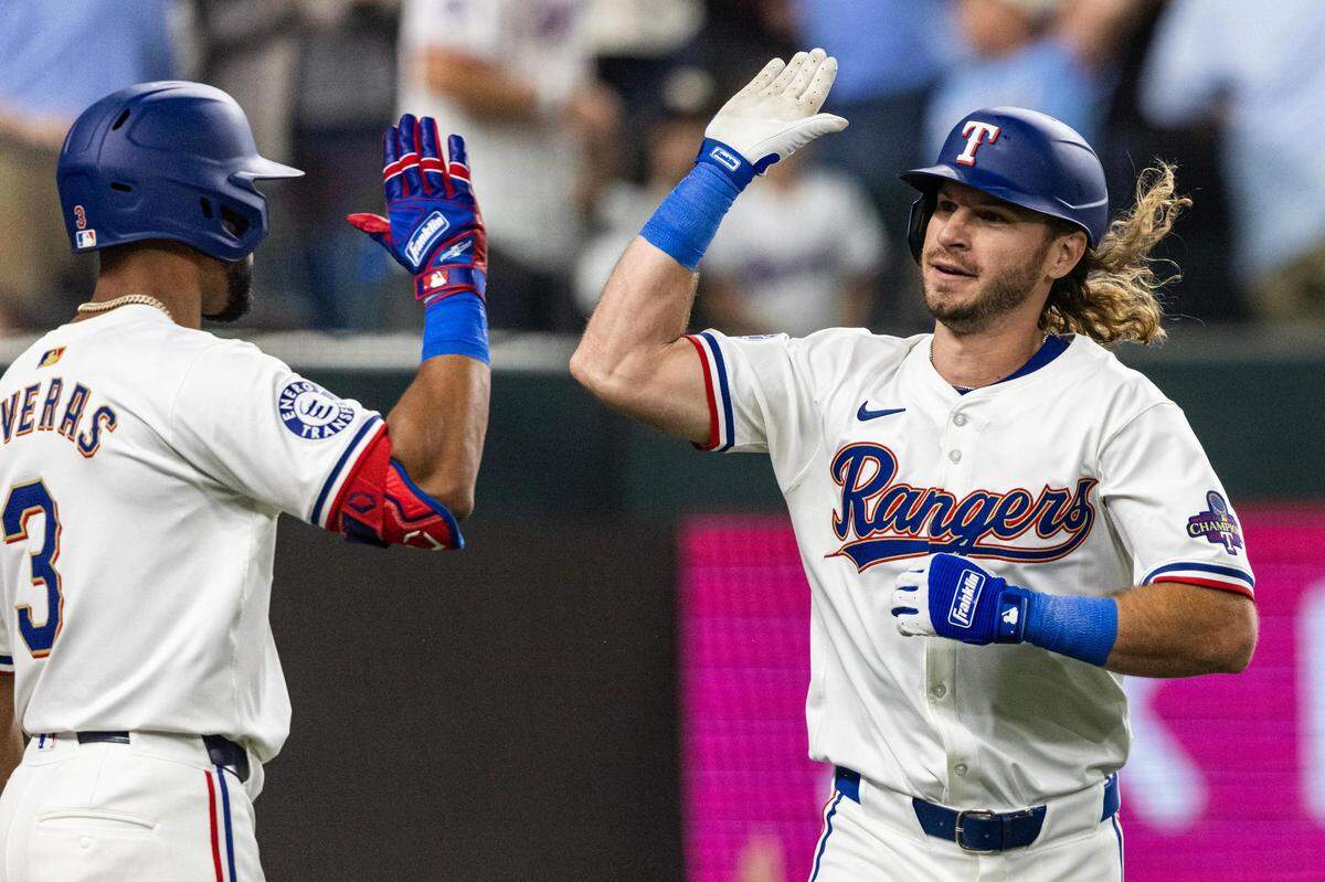 Texas Rangers outfielder Travis Jankowski (16) celebrates with his teammate Leody Taveras (3) after hitting the game tying home run in the ninth inning of their season opener against the Chicago Cubs at Globe Life Field in Arlington on Thursday, March 28, 2024.