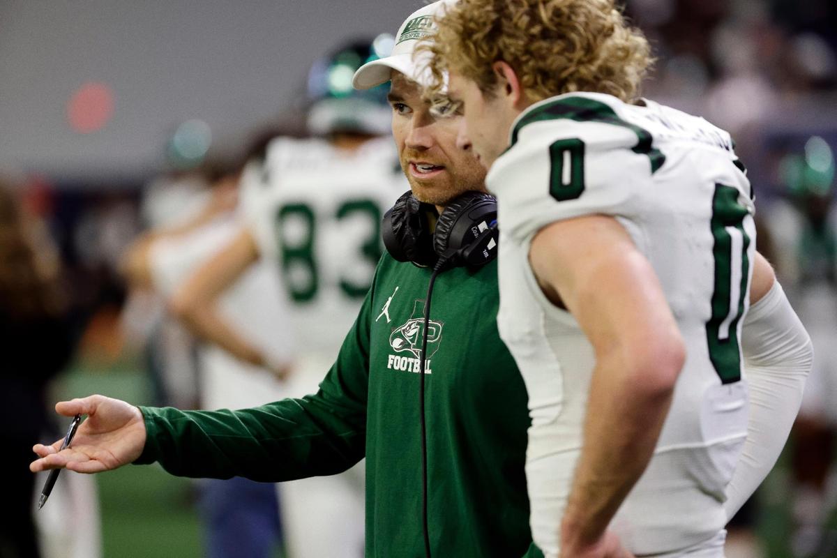 Prosper head coach Tyler Moore talks to quarterback Nathan TenBarge (0) on the sidelines in the second half of a UIL Class 6A Division 1 football regional-round playoff game at The Ford Center in Frisco, Texas, Saturday, Oct. 25, 2023.