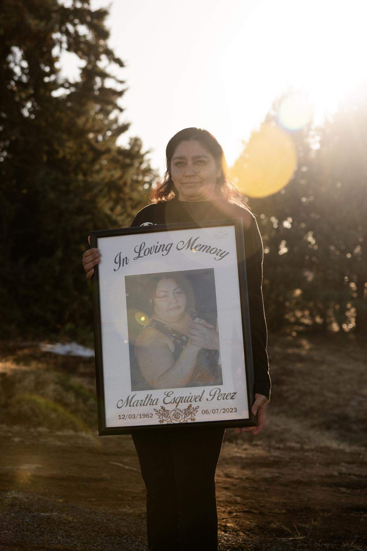 Evangelina Perez poses while holding a photo of her mother, Martha Perez, down the street from her home in Prescott Valley, Arizona, on Sunday, March 9 2025.