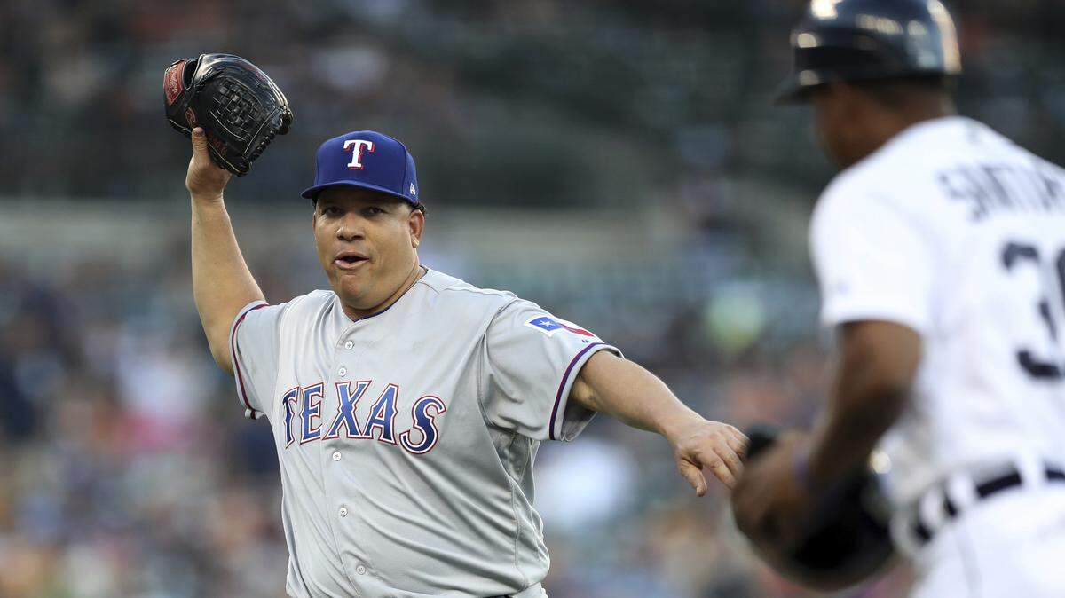 Rangers starting pitcher Bartolo Colon gestures to Detroit Tigers first base coach Ramon Santiago as he walks back to the dugout after the fifth inning on Friday night at Comerica Park. Colon took the loss despite holding the Tigers to three runs on five hits over eight innings.