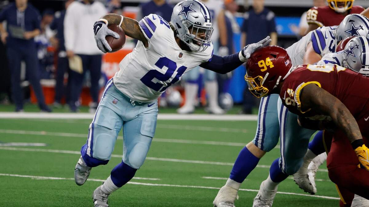 Dallas Cowboys running back Ezekiel Elliott (21) fights off a tackle attempt by Washington defensive tackle Daron Payne (94) during an NFL football game in Arlington, Texas, Sunday, Dec. 26, 2021. (AP Photo/Michael Ainsworth)