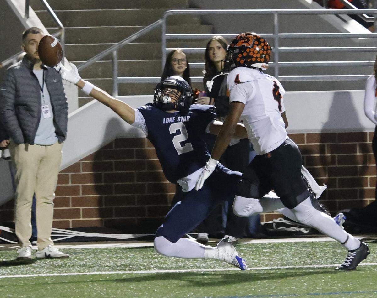 Frisco Lone Star wide receiver Logan Brown (2) almost hauls in a finger tip pass defended by Aledo corner back Alex Patton (4) during the first half of a UIL Class 5A Division I Semifinal on Friday Dec. 12, 2025 at Vernon Newsom Stadium in Mansfield, Texas.