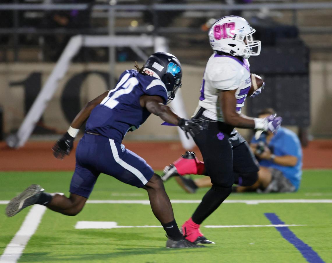 Paschal running back Marquez Dean (20) escapes Wyatt defensive end Malikhi Mingo (22) down the sidelines during a District 4-5A Division 1 football game at Herman Clark Stadium in Fort Worth, Texas, Thursday, Oct. 24, 2024.