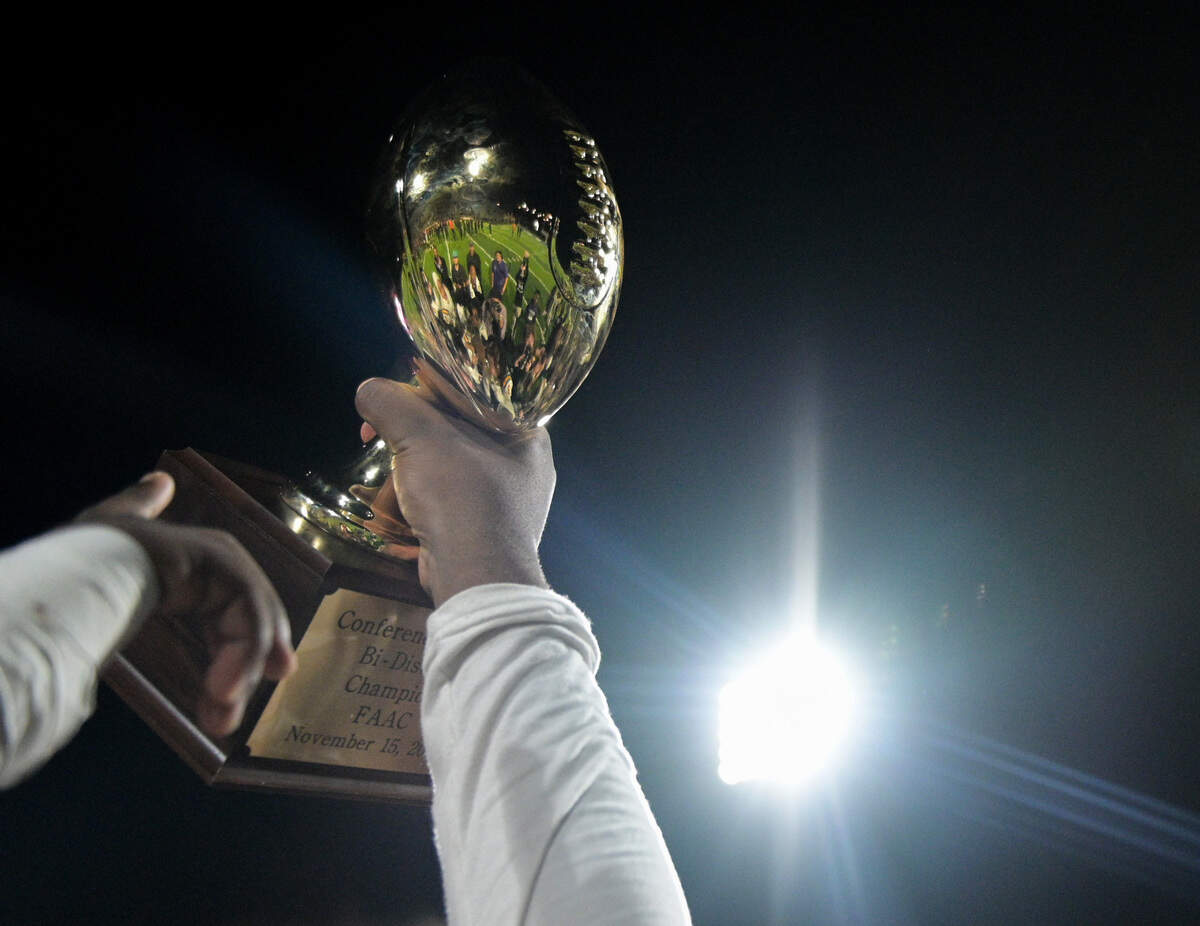 A Richardson Eagles player lifts the bi-district trophy after a UIL playoff football game against Haltom at Birdville ISD FA/AC in North Richland Hills, Texas on Friday, Nov. 15, 2024.