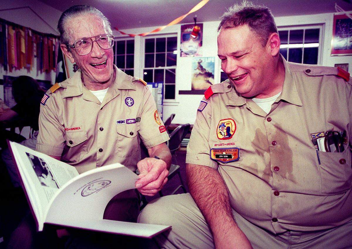 Oct. 16, 2000: Ernest Doclar, left, the chartered organization representative, and John Quinn Jr., a troop committee member and merit badge counselor, laugh as they look through a Boy Scouts history book at a meeting at St. Francis Catholic Church in Grapevine. Doclar has been a member of Troop 7 for 20 years, and Quinn has been with the troop off and on for almost 40 years.