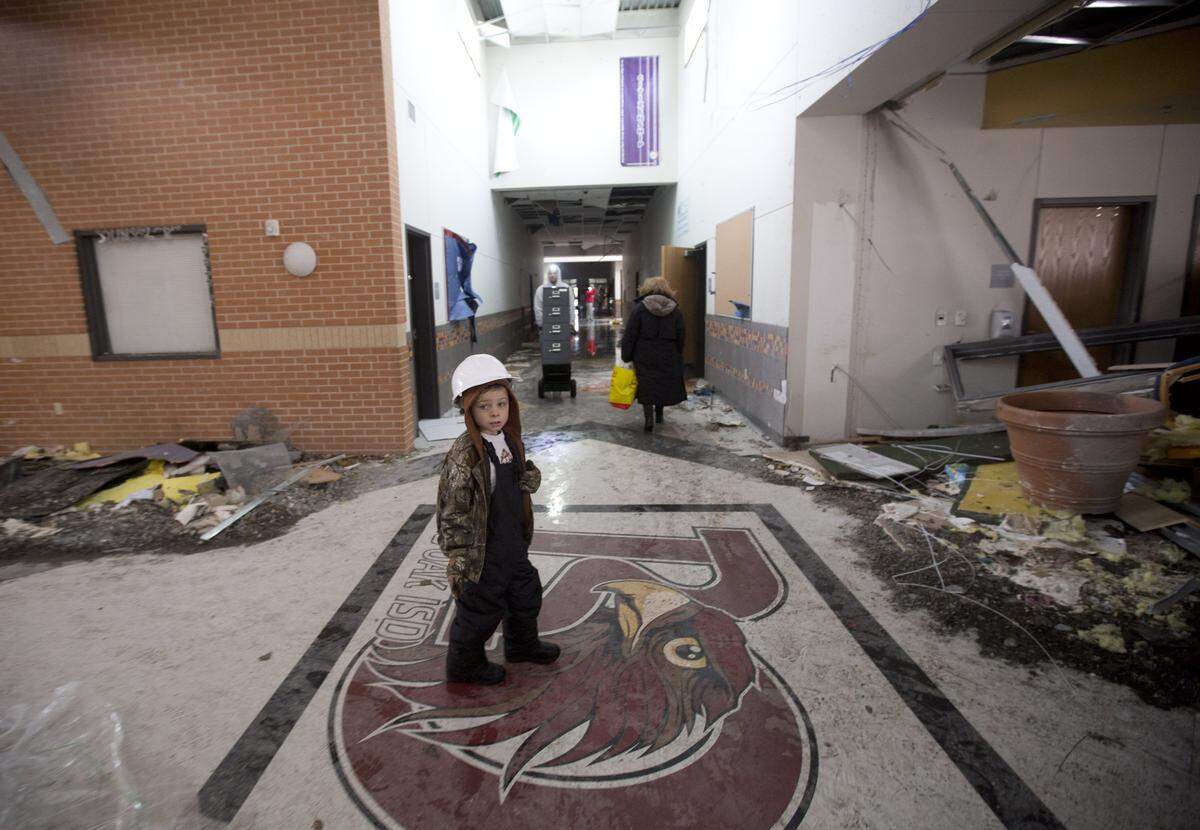 Jake Trice looks through the tornado-damaged rubble of his third-grade classroom at Donald T. Shields Elementary School in Glenn Heights, south of Dallas, on Dec. 28, 2015.  