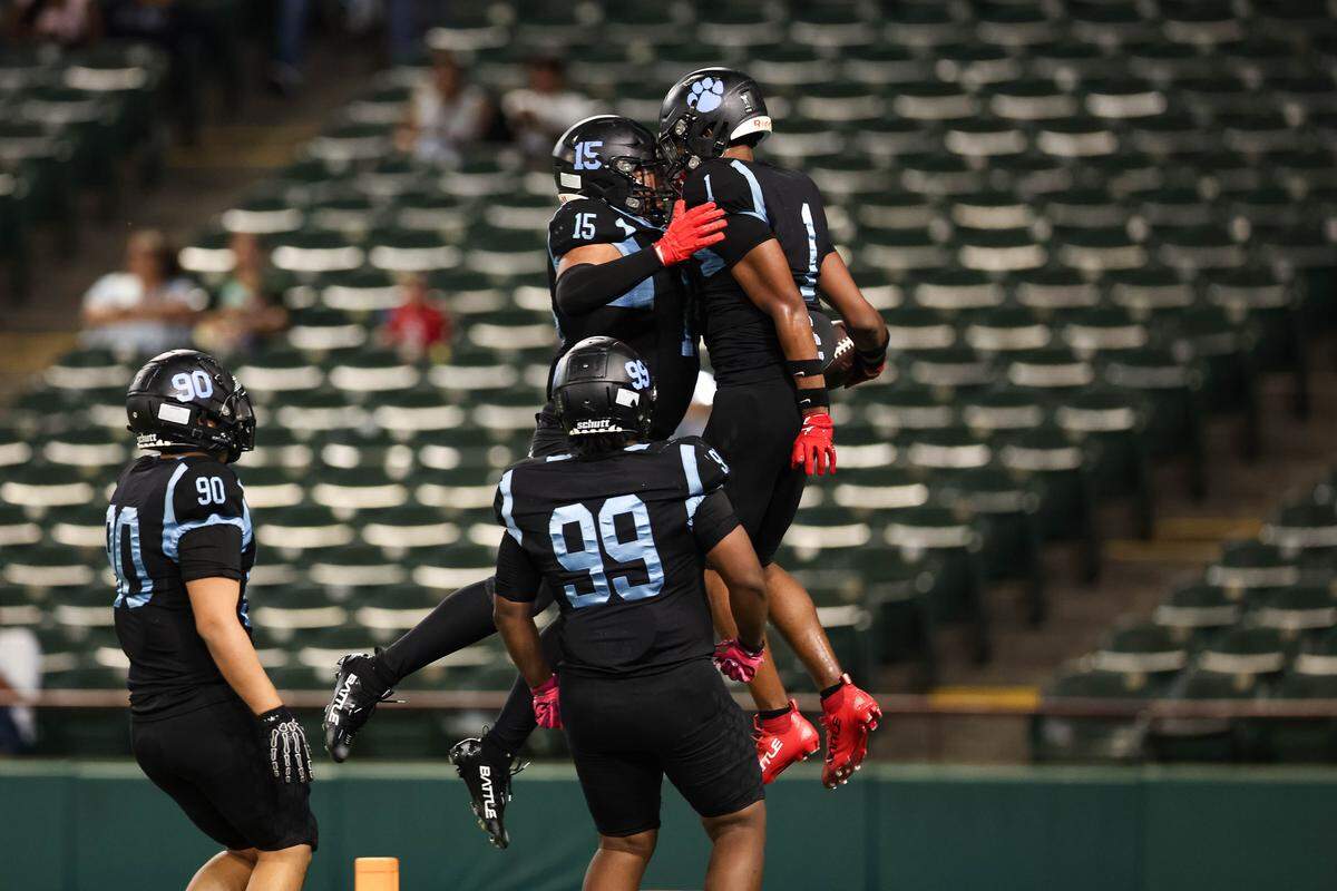 Arlington Seguin linebacker Da'Shaun Marable celebrates with a jump with his teammates after intercepting a pass that resulted in a defensive touchdown in a district game between Arlington Seguin and Burleson at Choctaw Stadium in Arlington, Texas on Sept. 11, 2025.