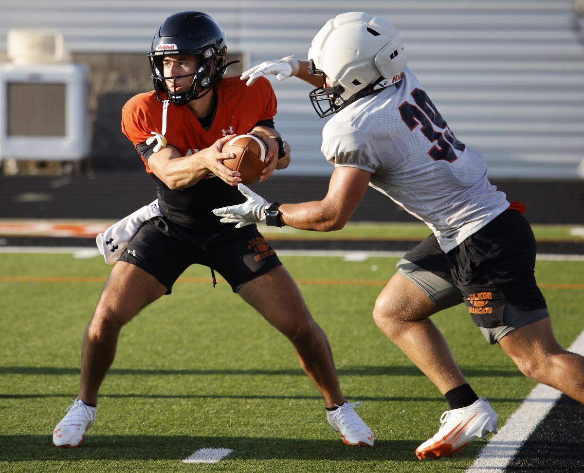 Quarterback Lincoln Tubbs hands off the ball to fullback Brady Powell during Aledo High School's morning practice at Tim Buchanan Stadium in Aledo, Texas, Monday August, 18, 2025.