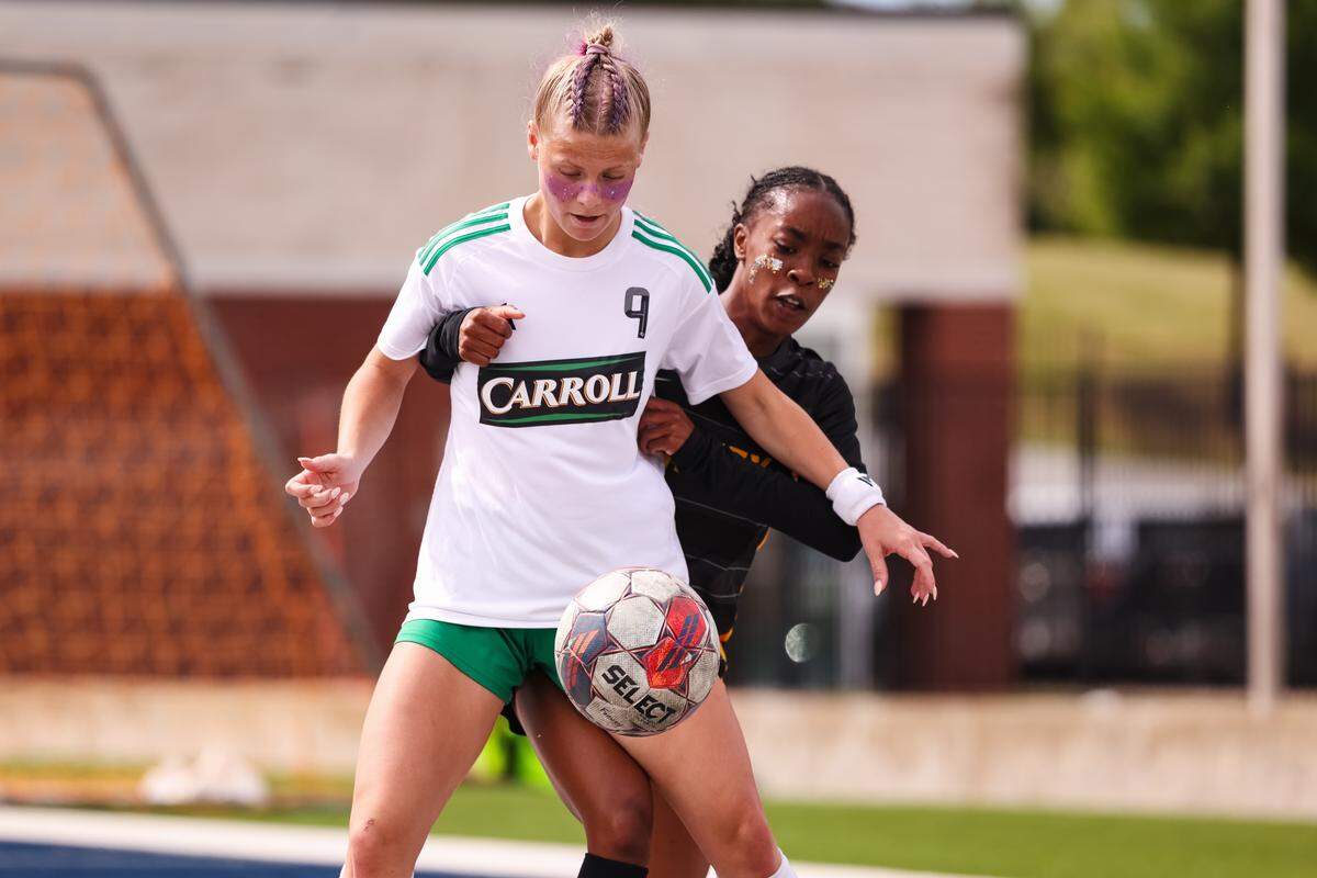 Southlake Carroll striker Caroline Holcombe (9) is held by a Forney defender while attempting to gain possession of the ball in a UIL Class 6A Division 2 girls soccer state semifinal on Saturday, April 4, 2026, at Memorial Stadium in Mesquite, Texas.