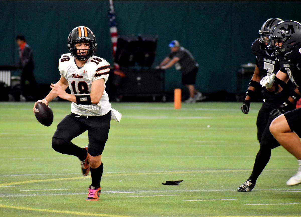 Haltom quarterback Gage Seely scrambles while being pursued by Arlington James Martin defenders in the first quarter of a UIL football game at Choctaw Stadium on Friday, Oct. 18, 2024.