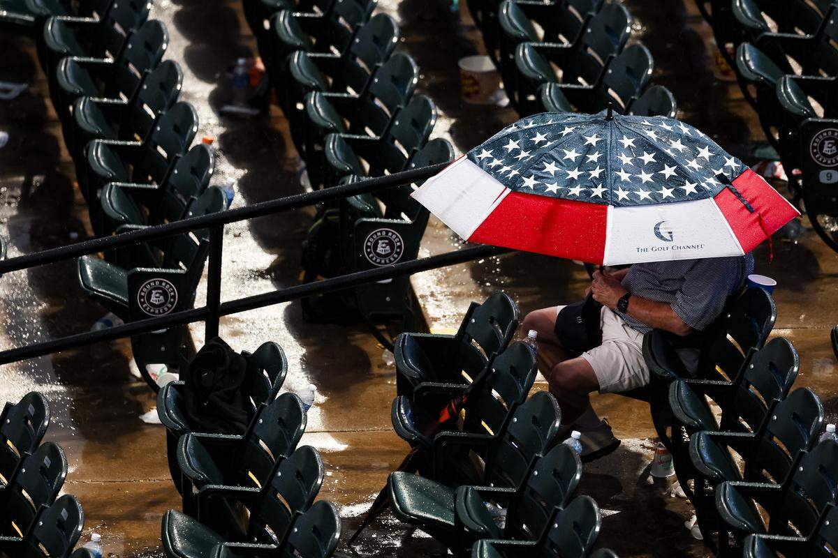 A fan sits in the rain during the UIL Texas high school baseball state championships at Dell Diamond in Round Rock, Texas, on Friday. June 5, 2026.