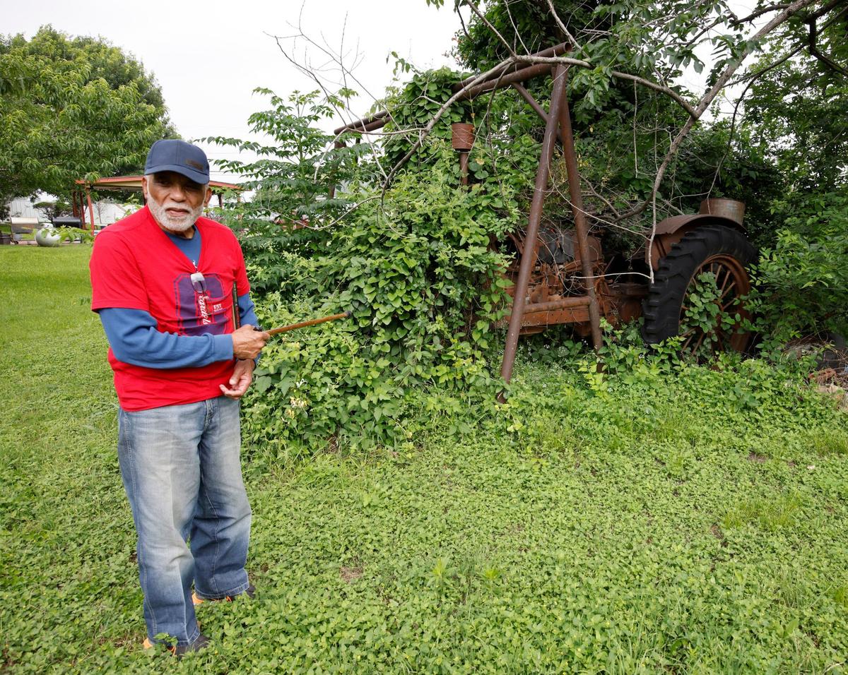 Drew Sanders points out a 1930 era crank start tractor that time has forgot in Fort Worth, Texas, Friday May 24, 2024. The Sanders have lived in The Garden of Eden, also known as a Freedman’s Community, almost since the neighborhoods beginnings.