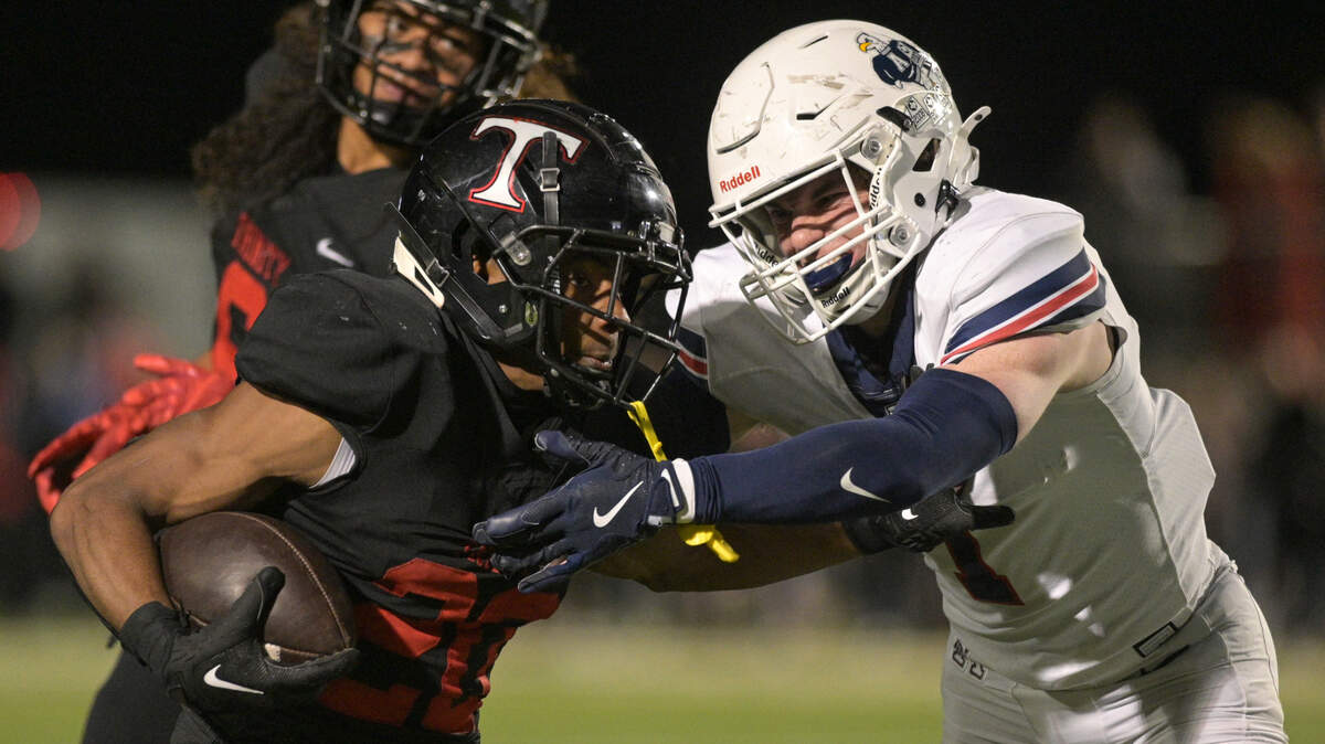 Trinity running back Joshua Bell (20) fends off an Allen Eagle defender during a UIL football playoff game against Allen High School at Dragon Stadium in Southlake, Texas on Friday, Nov. 29, 2024.