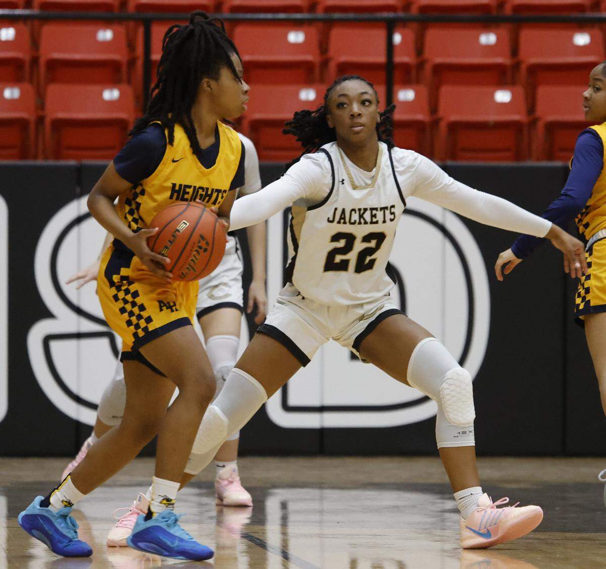 Cleburne guard Arajai Burks (22) defends against Arlington Heights guard Taniyah Clemons (13) during the first half of the UIL 5A D1 girls bi-district championship basketball game at Wilkerson Greines Activity Center in Fort Worth, Texas, Monday Feb. 16, 2026.