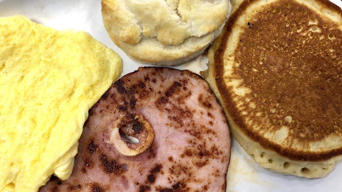 A ham-and-eggs platter with a pancake and biscuit at River Bend Cafe in Fort Worth.