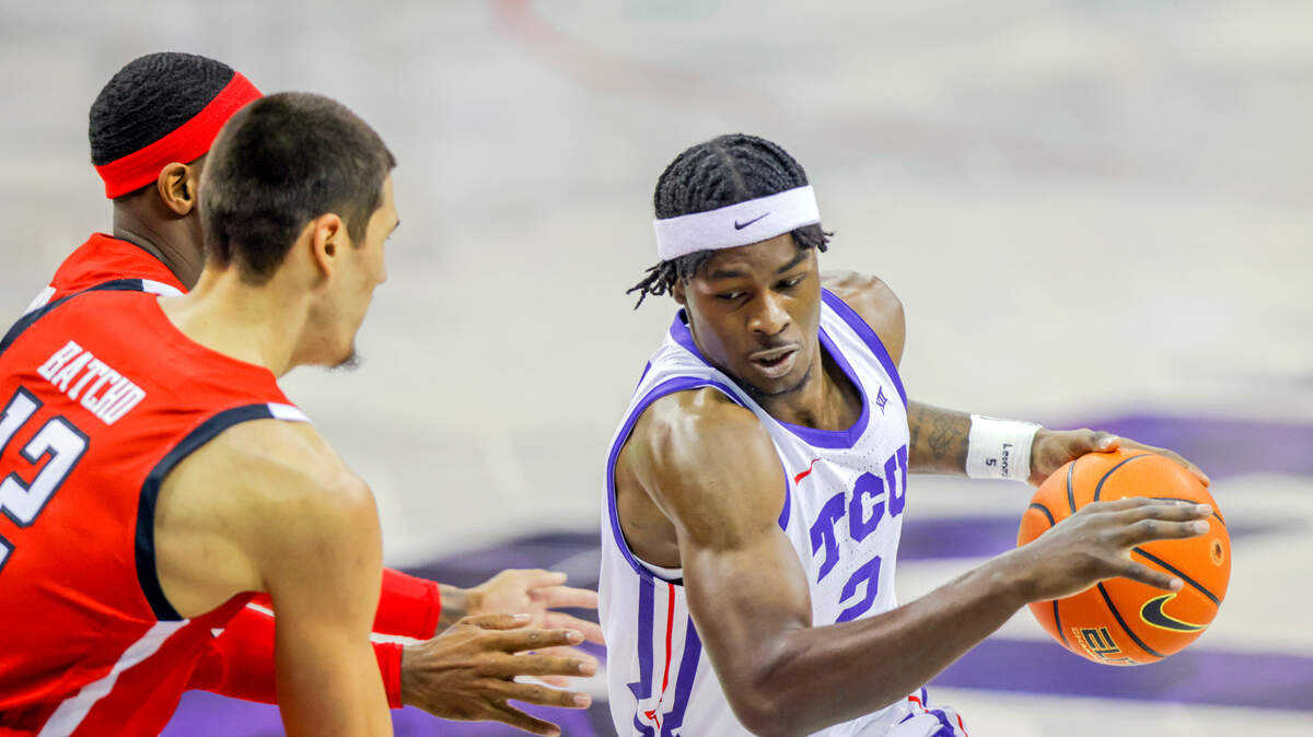 TCU forward Emanuel Miller (2) drives to the basket against Texas Tech defenders Daniel Batcho, front left, and De’Vion Harmon, back left, during their 2022 game in Fort Worth.