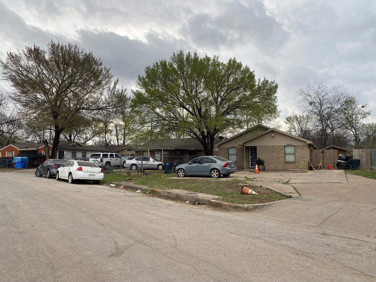 Bullet holes can be seen in cars parked on Vinson Street in Fort Worth, where a 9-year-old child was injured in a drive-by shooting.