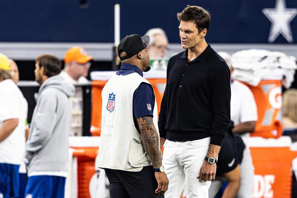 Former Patriots and Buccaneers quarterback Tom Brady speaks with former Panthers wide receiver Steve Smith Sr. prior to a preseason game between the Dallas Cowboys and Las Vegas Raiders at AT&T Stadium in Arlington, Texas on Saturday, Aug. 26, 2023.