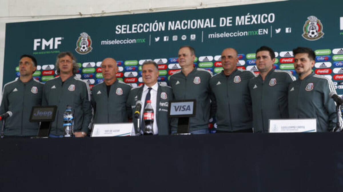 Gerardo Martino, center wearing a tie, is presented as the new coach of Mexico’s national soccer team, along with the team’s new technical staff, as they pose for photos during a press conference in Mexico City, Monday, Jan. 7, 2019. (AP Photo/Marco Ugarte)