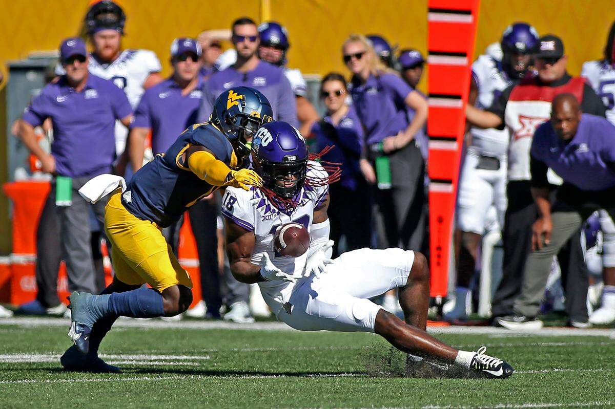 TCU wide receiver Savion Williams (18) catches a pass as West Virginia cornerback Wesley McCormick (11) defends during the first half of an NCAA college football game in Morgantown, W.Va., Saturday, Oct. 29, 2022. (AP Photo/Kathleen Batten)
