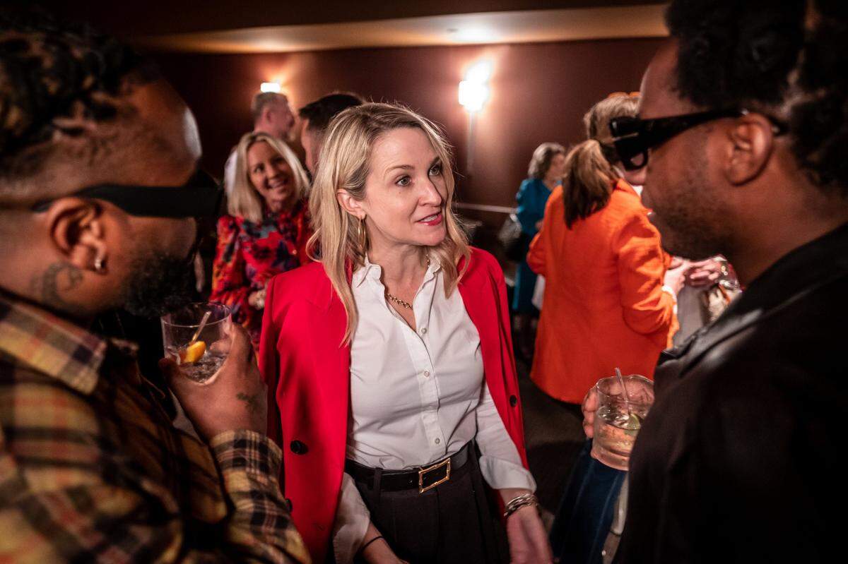 Fort Worth Mayor Mattie Parker (center) speaks to recording artist Leon Bridges (right) and another man at an event. 