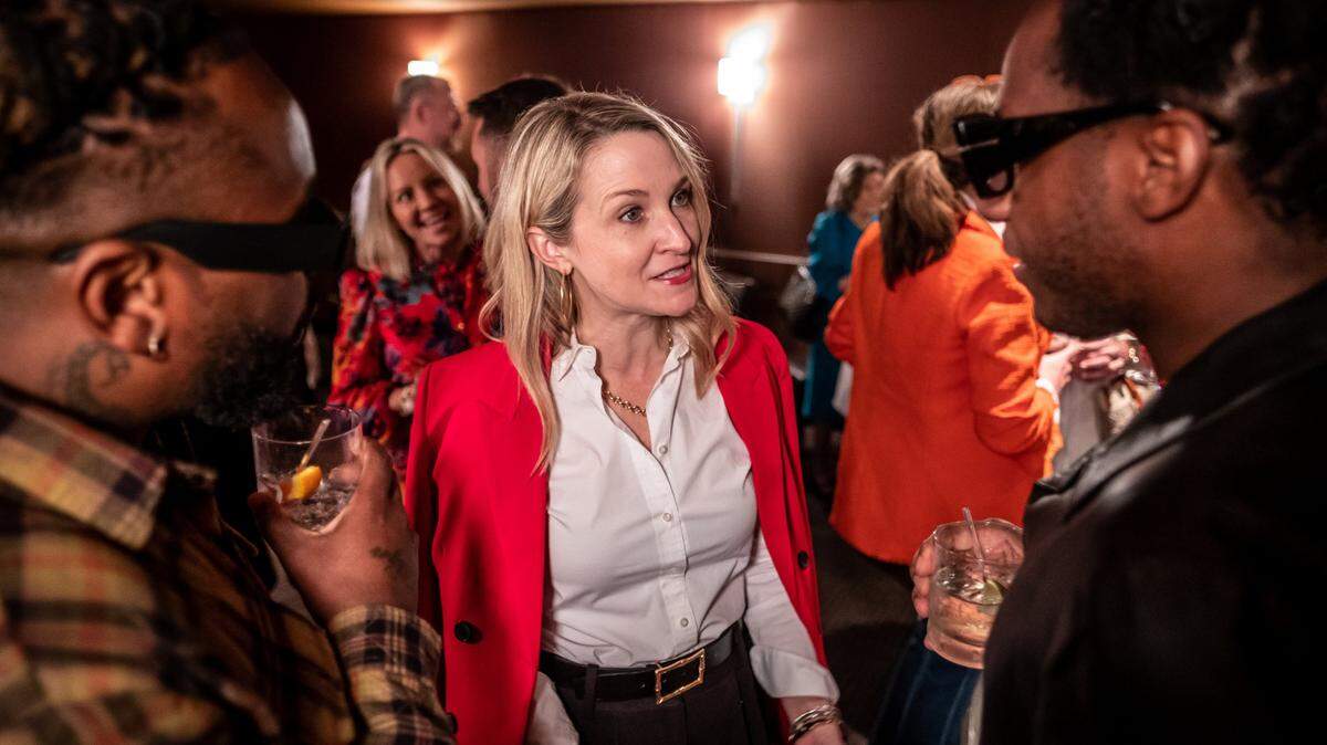 Fort Worth Mayor Mattie Parker (center) speaks to recording artist Leon Bridges (right) and another man at an event. 