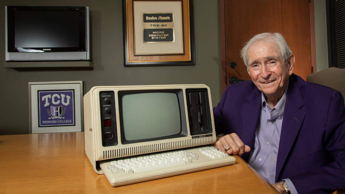 Former chairman and CEO of Tandy Corp. and former chairman of the TCU Board of Trustees poses with one of the original Radio Shack TRS-80 Model 4P portable micro computers in his office in June 2021.