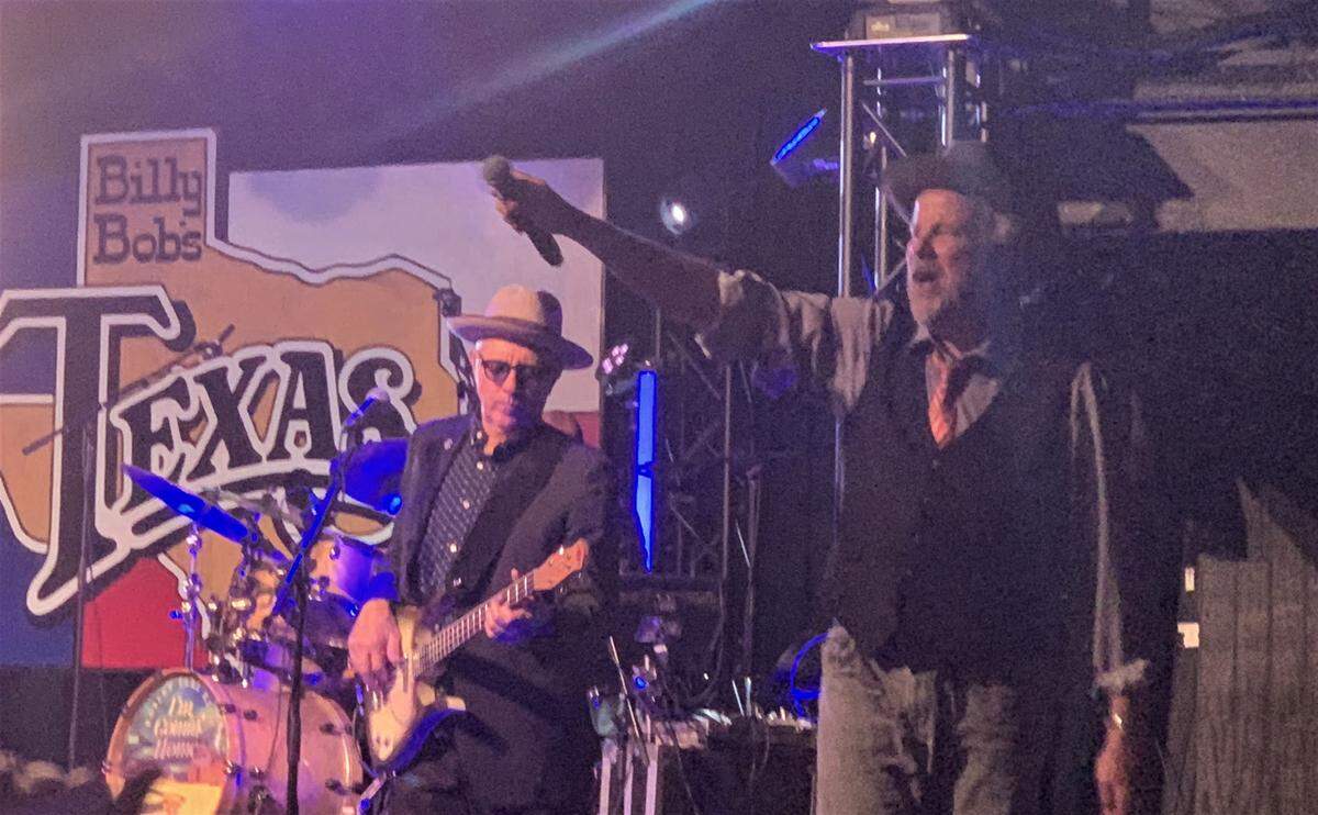Robert Earl Keen (right) urges the crowd to take the final chorus of “I’m Comin’ Home,” the last song in his show Aug. 25 at Billy Bob’s Texas in Fort Worth.