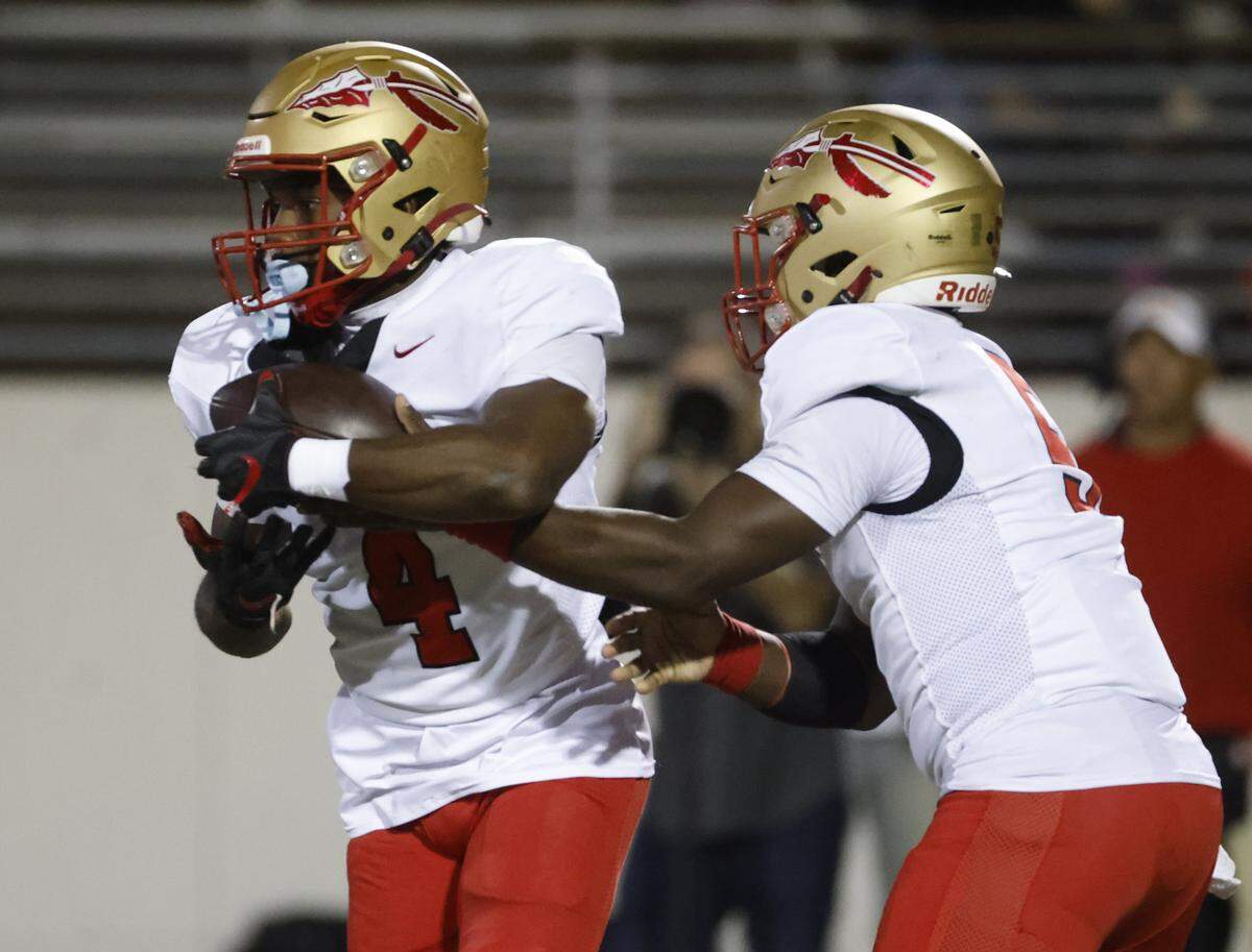 South Grand Prairie running back Josiah Lucas (4) takes the hand off from quarterback Daylon Brooks (5) during the first half of a UIL football game between South Grand Prairie and Arlington Bowie at UTA Maverick Stadium in Arlington, Texas, Thursday Nov. 06, 2025.
