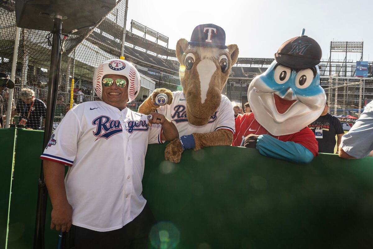 Glen Rose resident Jerry Garza takes a photo with Captain from theTexas Rangers and Billy the Marlin from the Miami Marlins for the first day of the 2024 MLB All-Star Village at Choctaw Stadium in Arlington on Saturday, July 13, 2024.